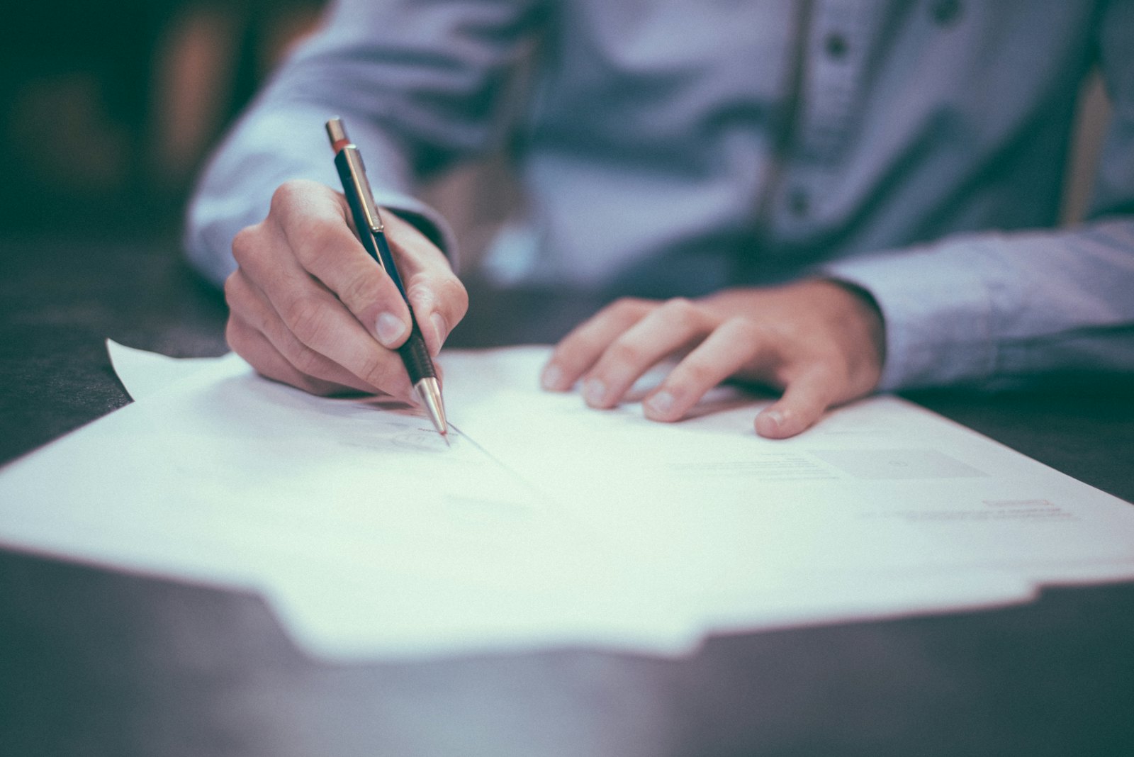 A desk with retirement planning documents, a notebook and a pen laid out for a consultation
